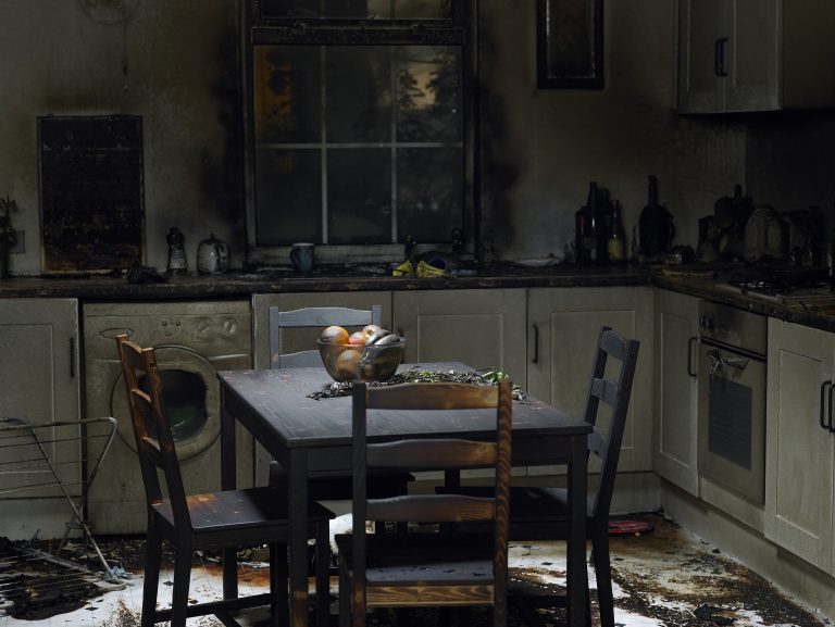 Photo of a kitchen, damaged by fire and smoke.
